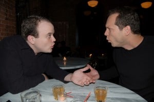 Writer and editor meet in restaurant. Both look passionate about what they're saying.