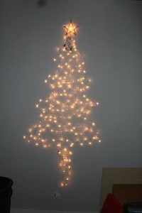 Make a Christmas tree on the wall with just a strand or two of lights and whatever ornaments you have on hand.