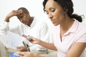 Couple going over bills, considering closing credit card accounts