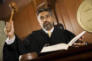 Court judge with raised gavel reading list of words that indicate judgment