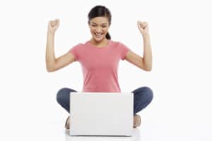 Available resources help with success. This woman looking at her laptop is cheering.