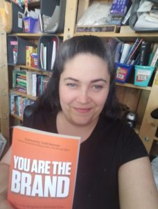 Photo shows the editor of You Are the Brand, Jennifer Harshman, holding the book.