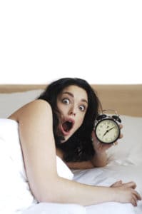 Use a printable clock to teach time zones because it will help people not be late for phone appointments. Image is of woman holding a clock and realizing she is late.