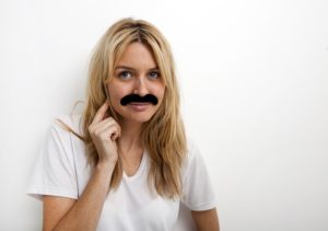 This woman with a fake mustache wonders if she's good enough to write a book and she is.